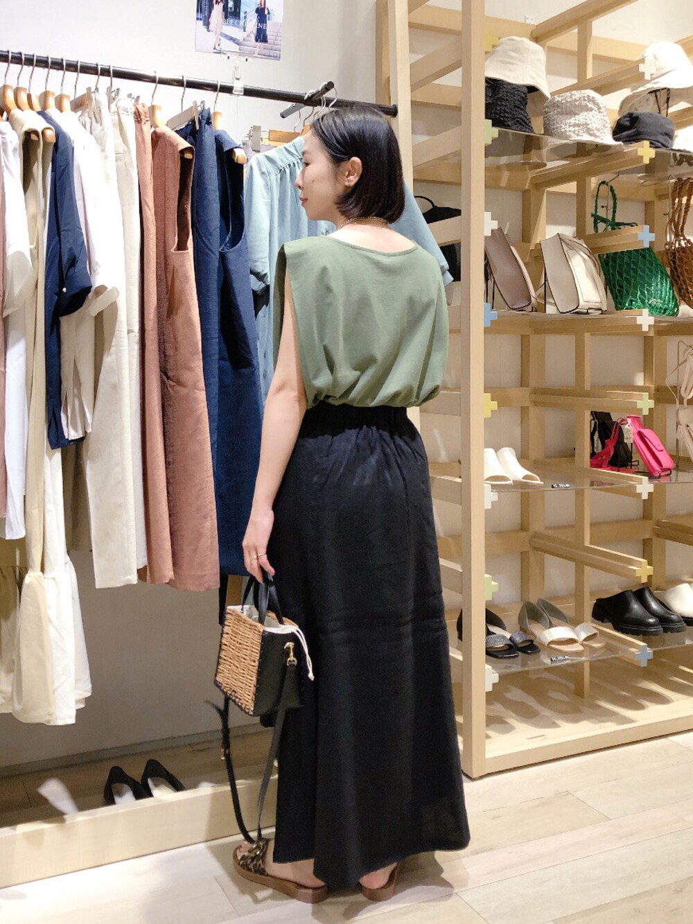 グリーン系のTシャツ/カットソー、ブラック系のスカート、ブラック系のショルダーバッグを着用したレディースの夏コーディネートの3枚目の写真