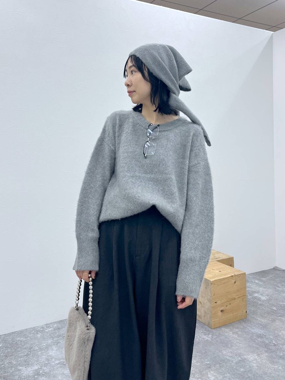 グレー系のその他パンツ、ブラウン系のショルダーバッグ、グレー系のニット/セーターを着用したレディースの秋コーディネートの2枚目の写真