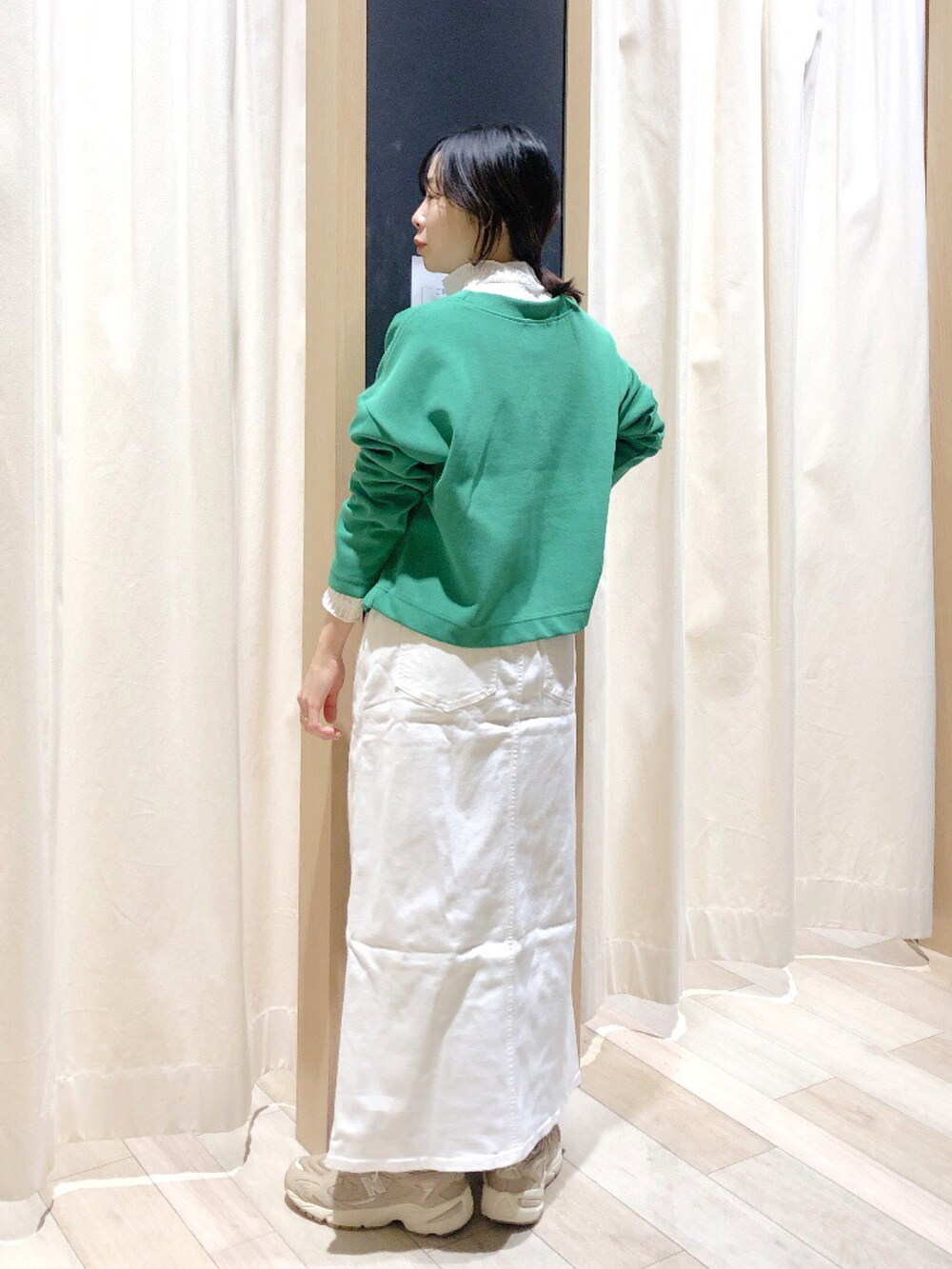 グリーン系のカーディガン/ボレロ、ホワイト系のTシャツ/カットソー、ホワイト系のデニムスカートを着用したレディースの冬コーディネートの4枚目の写真