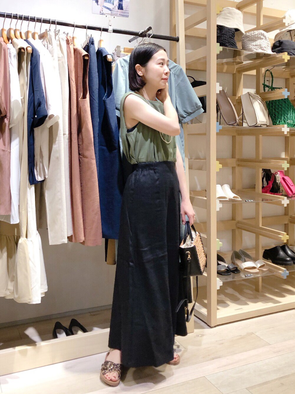 グリーン系のTシャツ/カットソー、ブラック系のスカート、ブラック系のショルダーバッグを着用したレディースの夏コーディネートの2枚目の写真