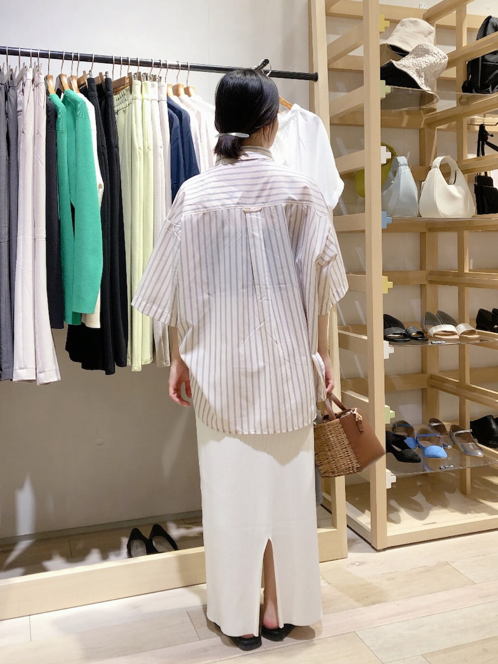 ピンク系のTシャツ/カットソー、ホワイト系のスカート、ブラウン系のショルダーバッグを着用したレディースの春コーディネートの2枚目の写真