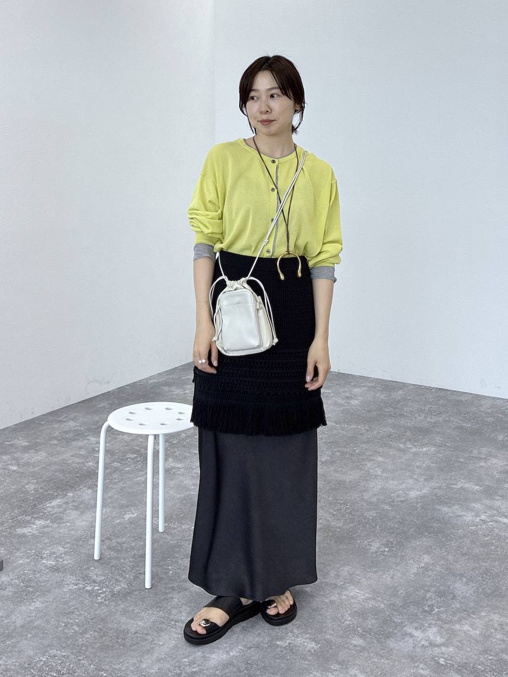 ブラック系のサンダル、イエロー系のカーディガン/ボレロ、ブラック系のスカートを着用したレディースの春コーディネートの4枚目の写真