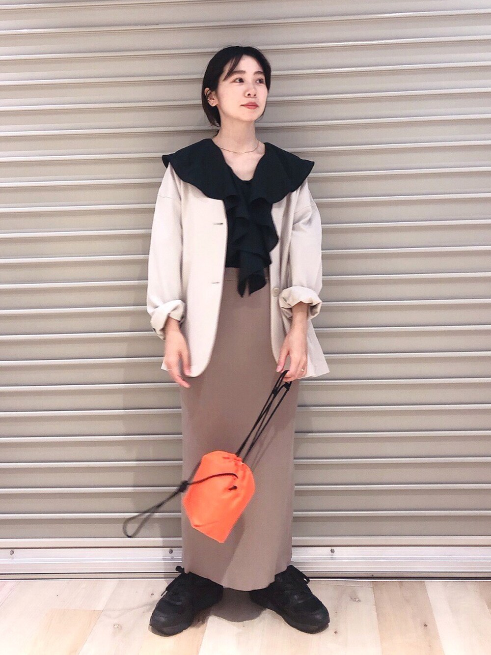 ブラック系のシャツ/ブラウス、ベージュ系のノーカラージャケット、ブラウン系のスカートを着用したレディースの秋コーディネートの2枚目の写真