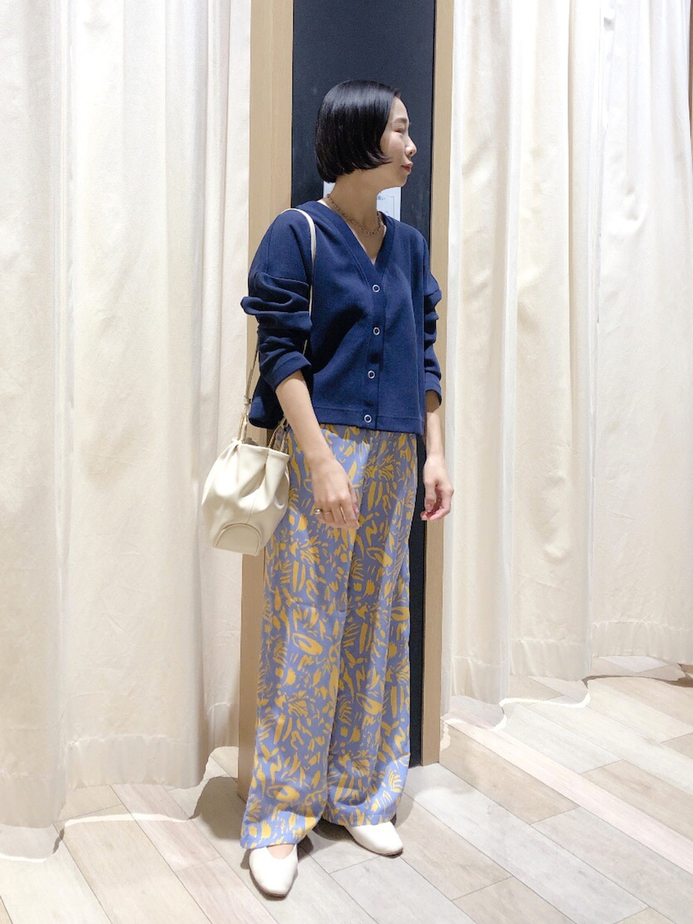 ホワイト系のハンドバッグ、ブルー系のカーディガン/ボレロ、ブルー系のその他パンツを着用したレディースの春コーディネートの2枚目の写真