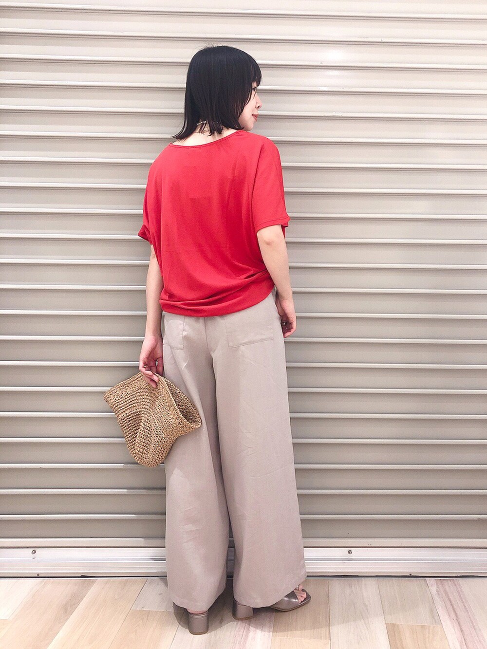 レッド系のTシャツ/カットソー、ベージュ系のその他パンツ、その他のサンダルを着用したレディースの春コーディネートの3枚目の写真