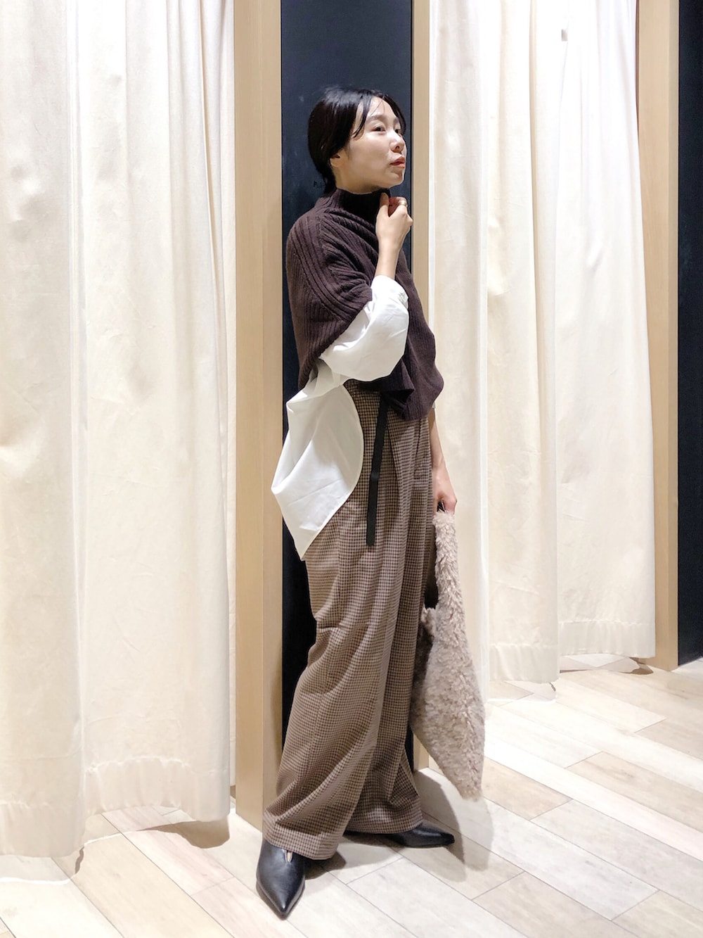 ブラック系のパンプス、ブラウン系のその他パンツ、ベージュ系のショルダーバッグを着用したレディースの秋コーディネートの2枚目の写真