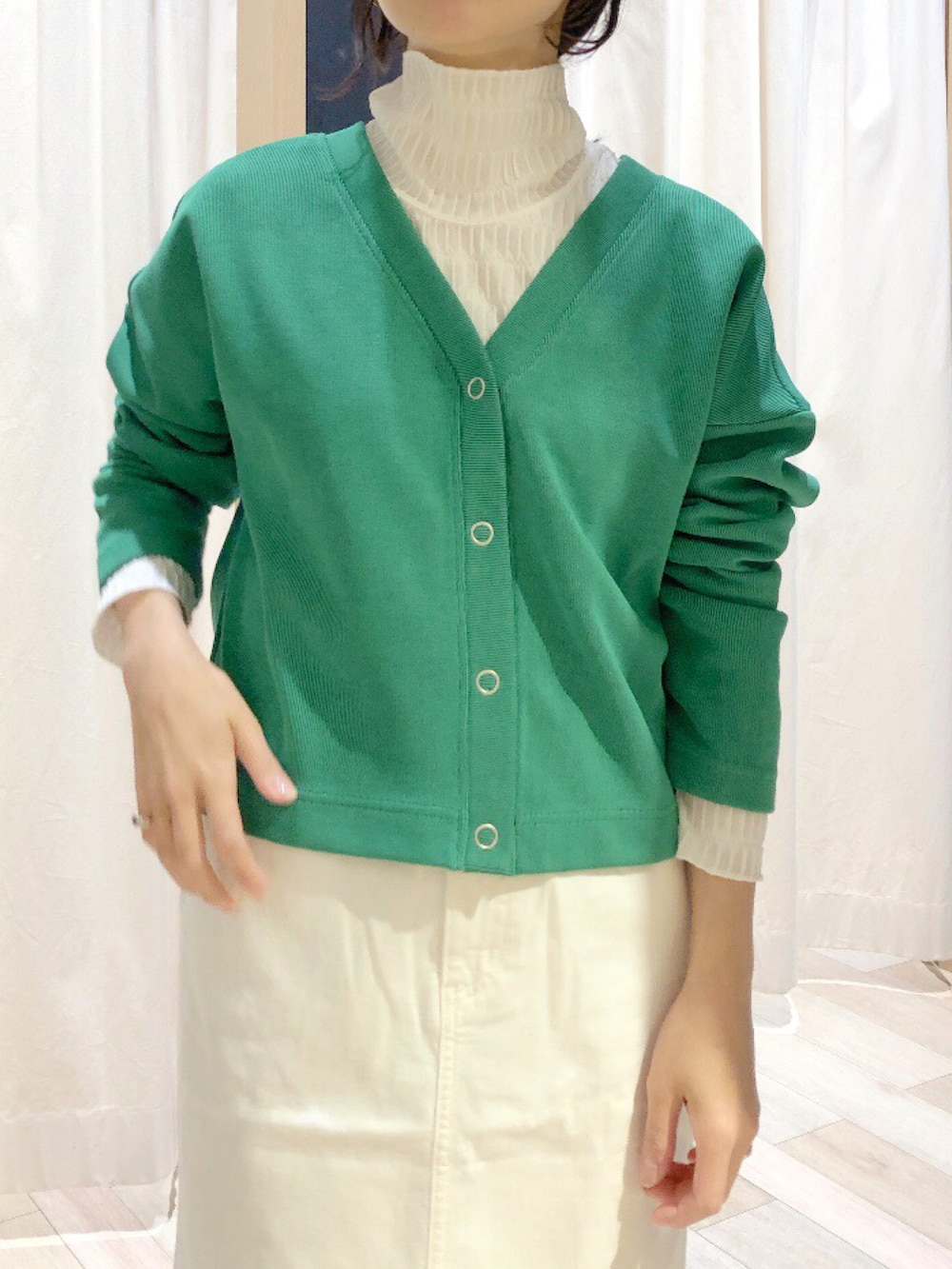 グリーン系のカーディガン/ボレロ、ホワイト系のTシャツ/カットソー、ホワイト系のデニムスカートを着用したレディースの冬コーディネートの2枚目の写真