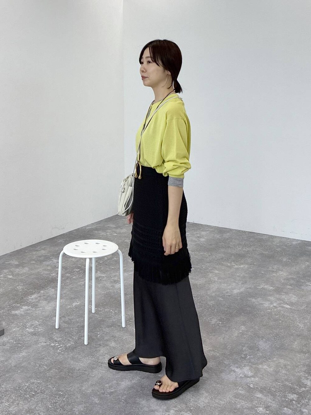 ブラック系のサンダル、イエロー系のカーディガン/ボレロ、ブラック系のスカートを着用したレディースの春コーディネートの2枚目の写真
