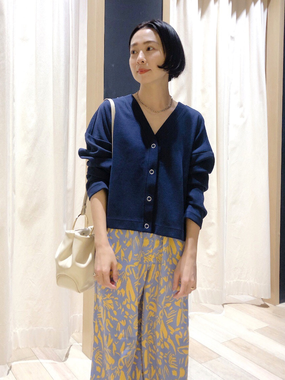 ホワイト系のハンドバッグ、ブルー系のカーディガン/ボレロ、ブルー系のその他パンツを着用したレディースの春コーディネートの3枚目の写真
