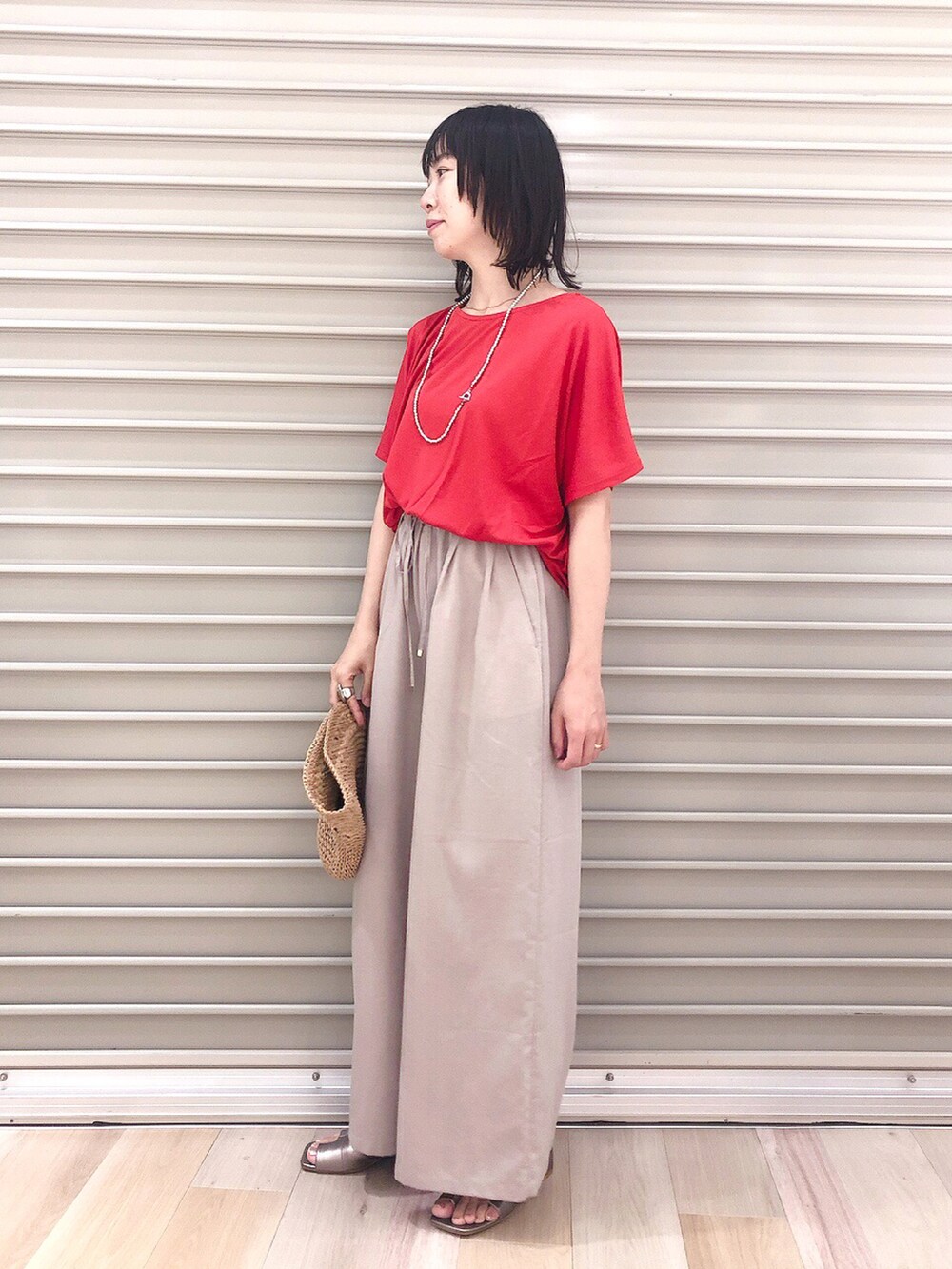 レッド系のTシャツ/カットソー、ベージュ系のその他パンツ、その他のサンダルを着用したレディースの春コーディネートの4枚目の写真