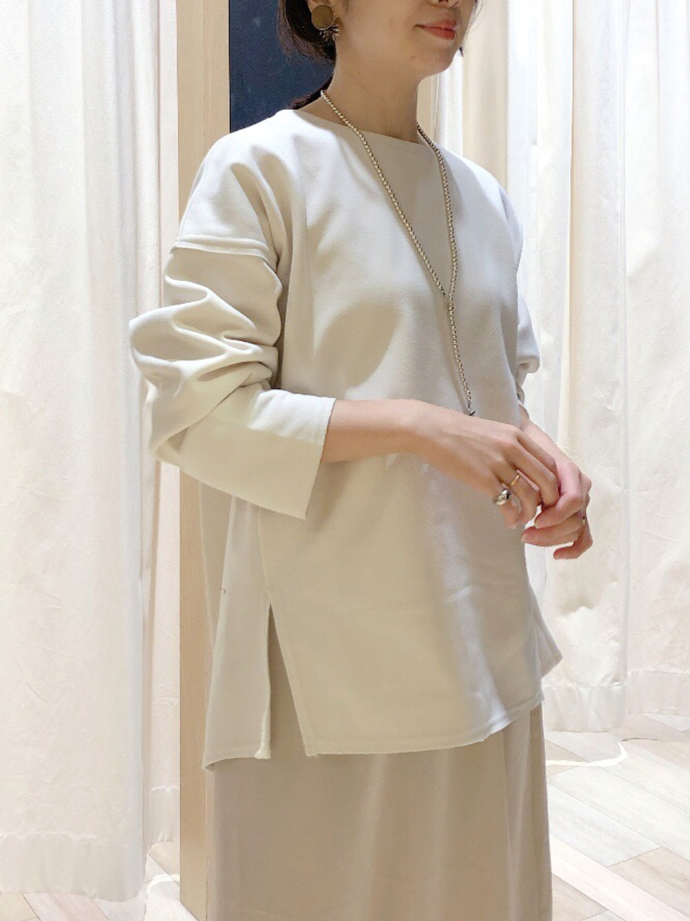 ホワイト系のTシャツ/カットソー、ベージュ系のスカート、レッド系のトップスを着用したレディースの冬コーディネートの3枚目の写真