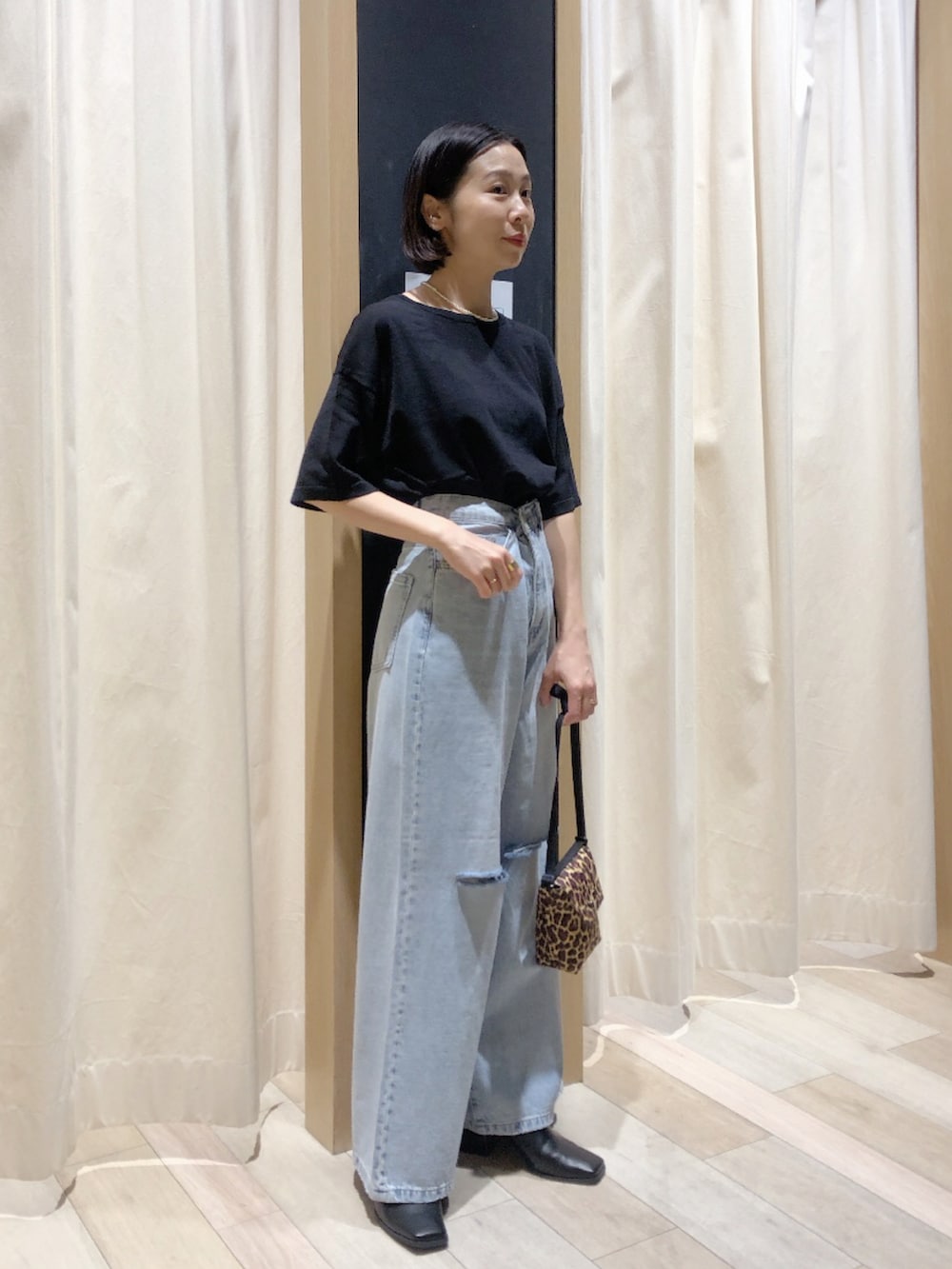 ブラック系のサンダル、ブルー系のデニムパンツ、ブラック系のニット/セーターを着用したレディースの春コーディネートの2枚目の写真