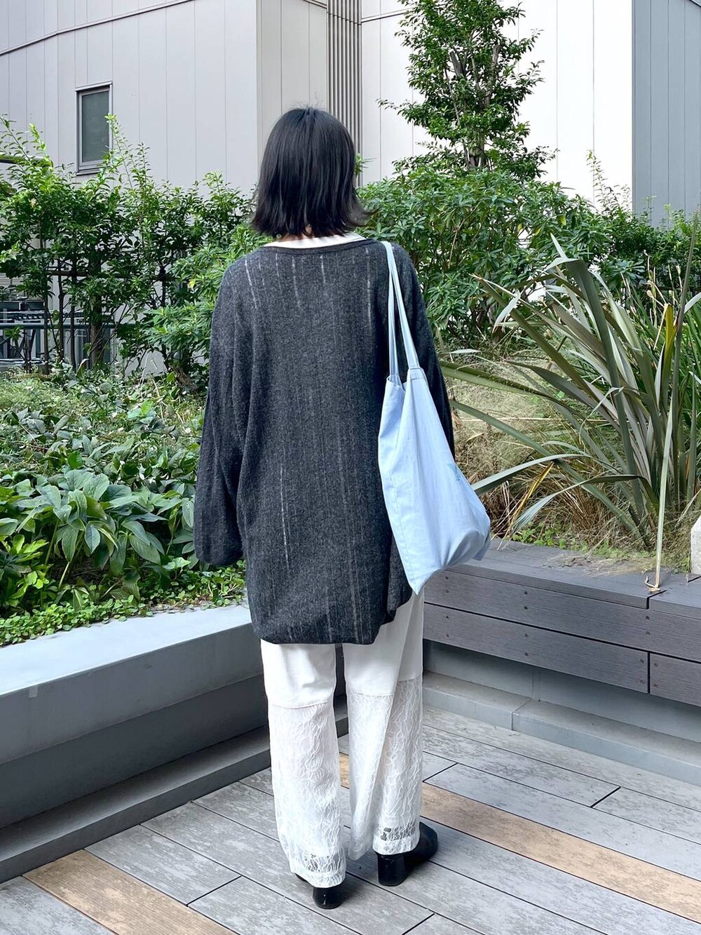 グレー系のチュニック、ホワイト系のその他パンツを着用したレディースの秋コーディネートの4枚目の写真
