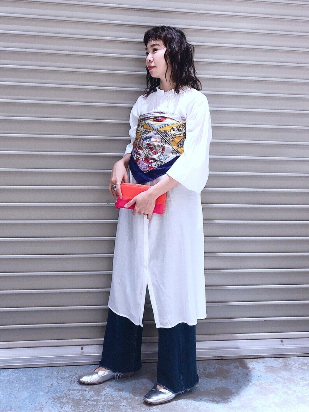 ホワイト系のワンピース、ブルー系のデニムパンツ、シルバー系のパンプスを着用したレディースの冬コーディネートの2枚目の写真