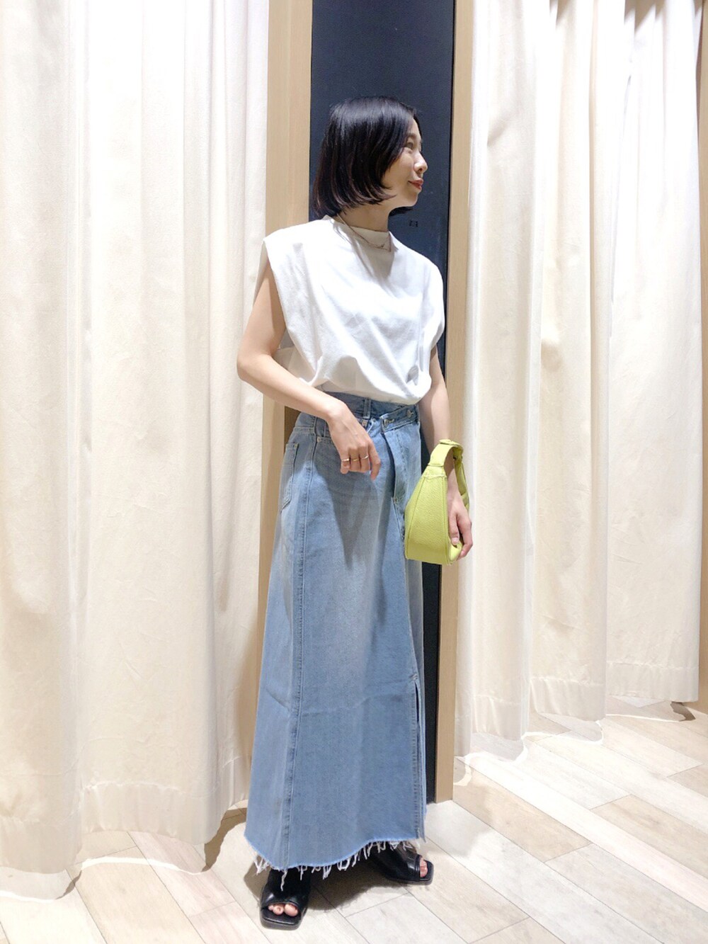 ブラック系のサンダル、ホワイト系のTシャツ/カットソー、ブルー系のスカートを着用したレディースの夏コーディネートの2枚目の写真