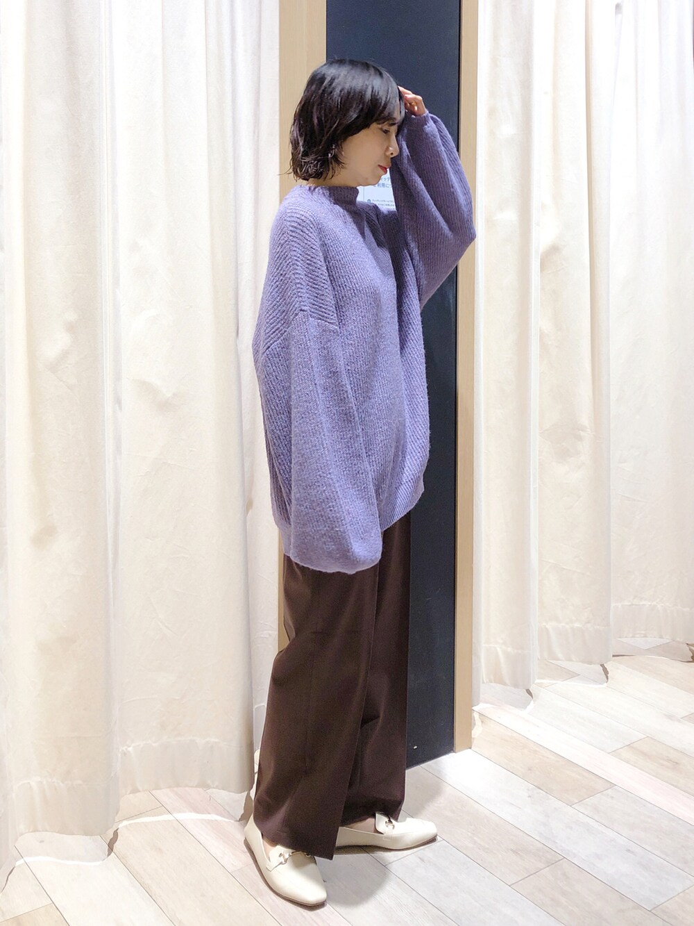 パープル系のニット/セーター、ブラウン系のスラックス、ホワイト系のローファーを着用したレディースの秋コーディネートの3枚目の写真