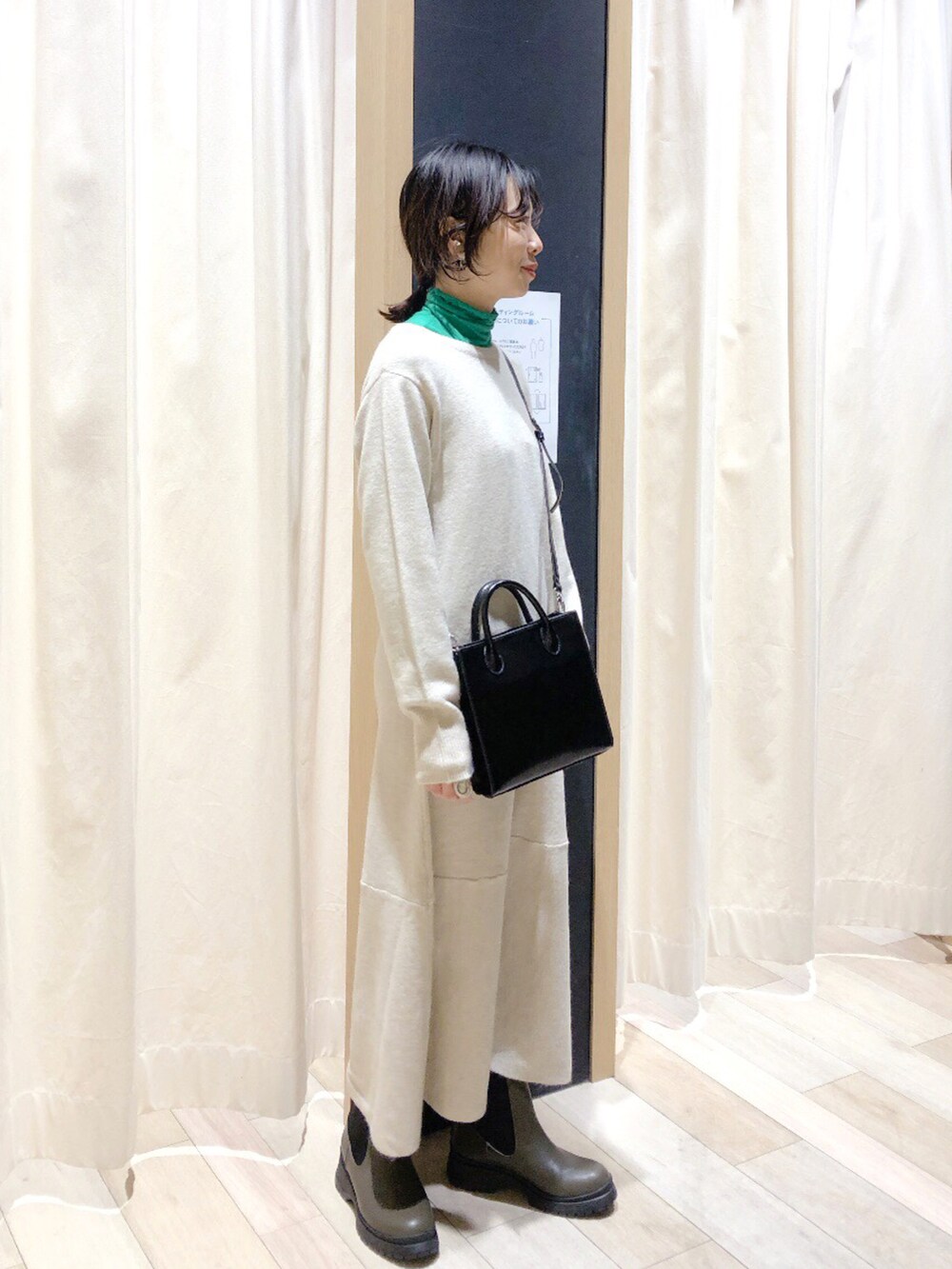 グリーン系のブーツ、ブラック系のショルダーバッグ、グリーン系のTシャツ/カットソーを着用したレディースの冬コーディネートの2枚目の写真