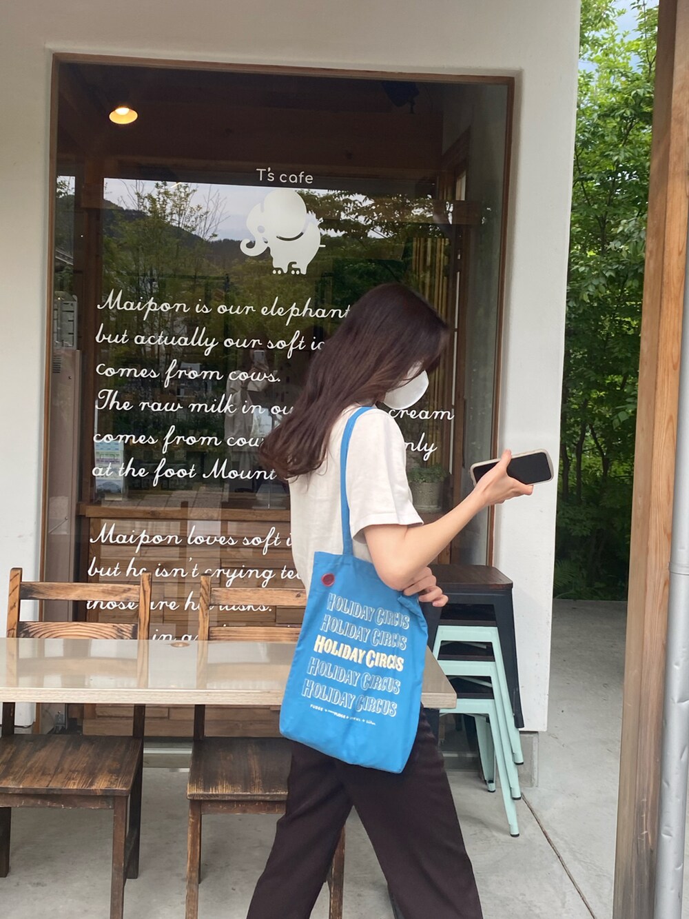 グリーン系のポロシャツ、ブラウン系のパンツ、ホワイト系のスニーカーを着用したレディースの夏コーディネートの2枚目の写真