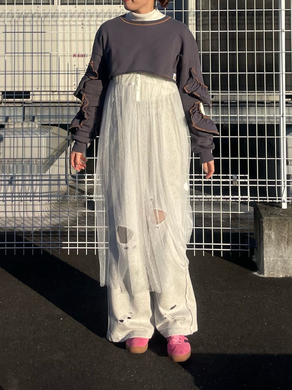 グレー系のスウェットパンツ、ピンク系のスニーカー、グレー系のスウェットを着用したレディースの冬コーディネートの2枚目の写真