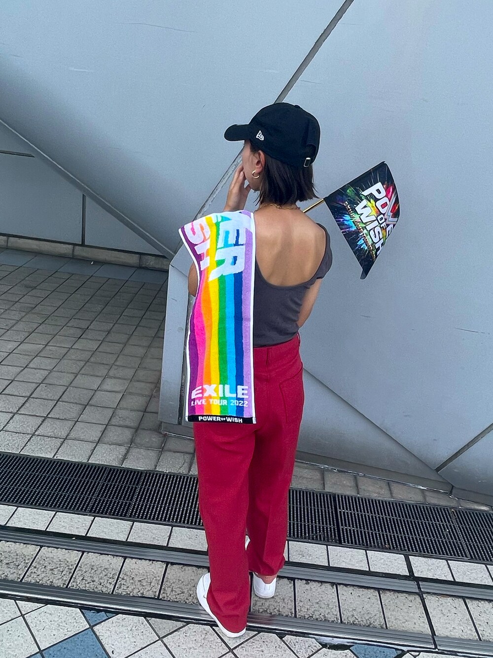 レッド系のチノパンツ、ホワイト系のスニーカー、グレー系のTシャツ/カットソーを着用したレディースの夏コーディネートの2枚目の写真