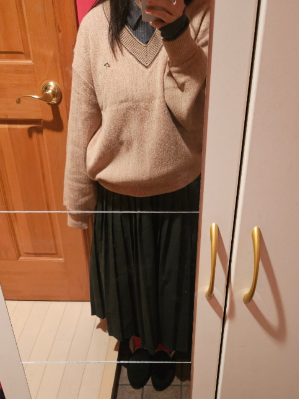 グレー系のカーディガン/ボレロ、グレー系のスカート、レッド系のストール/ショールを着用したレディースの秋コーディネートの2枚目の写真