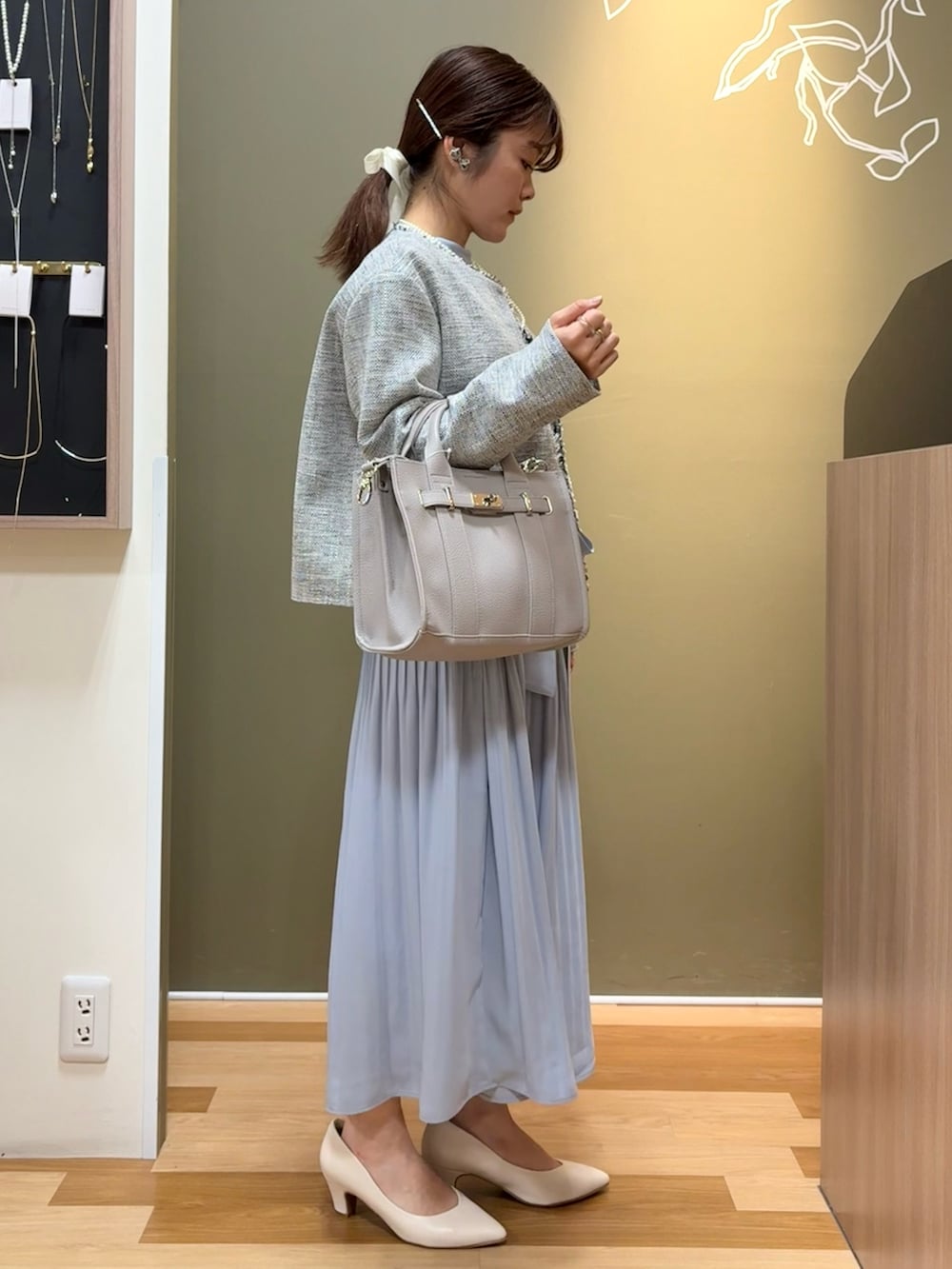 ホワイト系のパンプス、グレー系のハンドバッグ、ブルー系のワンピースを着用したレディースの冬コーディネートの2枚目の写真