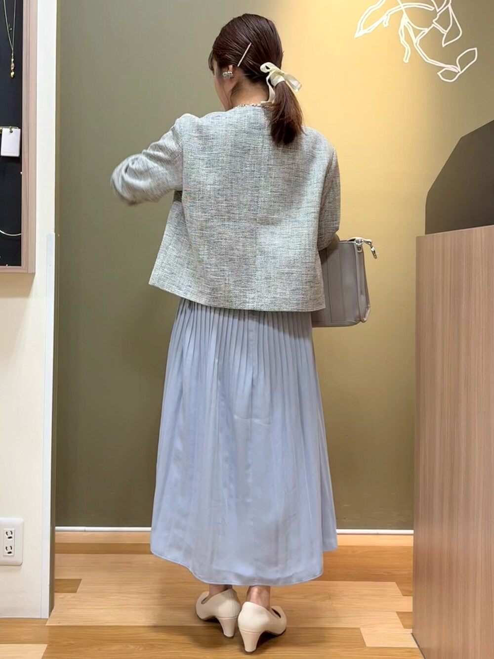 ホワイト系のパンプス、グレー系のハンドバッグ、ブルー系のワンピースを着用したレディースの冬コーディネートの3枚目の写真