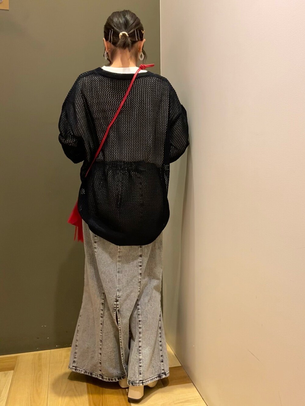 ブラック系のニット/セーター、ブラック系のTシャツ/カットソー、レッド系のショルダーバッグを着用したレディースの春コーディネートの3枚目の写真