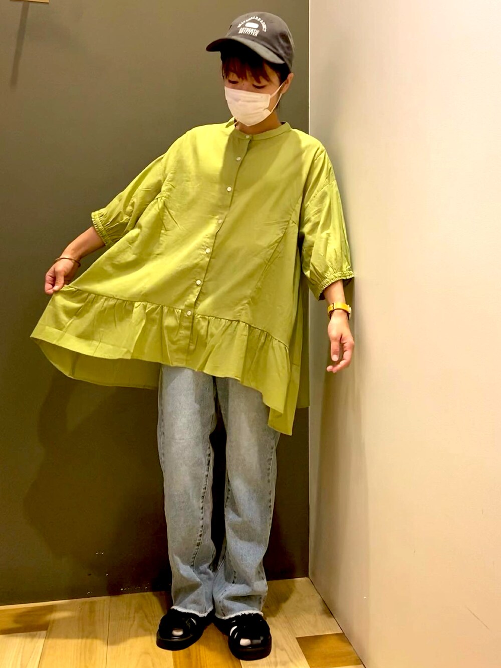 グリーン系のシャツ/ブラウス、ホワイト系のタンクトップ、ブラック系のサンダルを着用したレディースの夏コーディネートの2枚目の写真