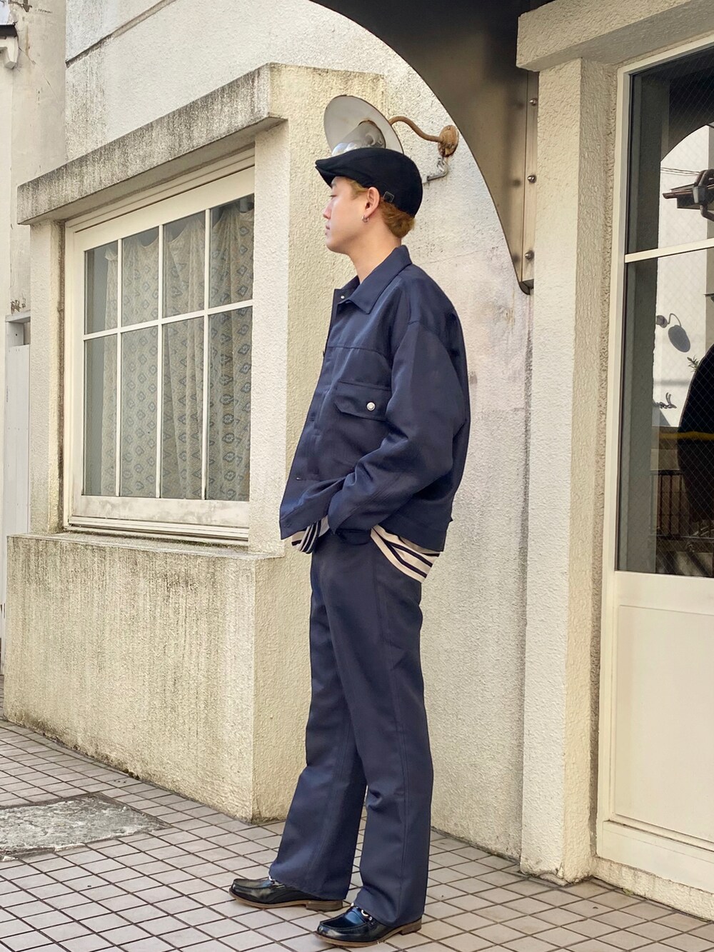 ブルー系のブルゾン、ブルー系のTシャツ/カットソー、ブルー系のスラックスを着用したメンズの冬コーディネートの2枚目の写真