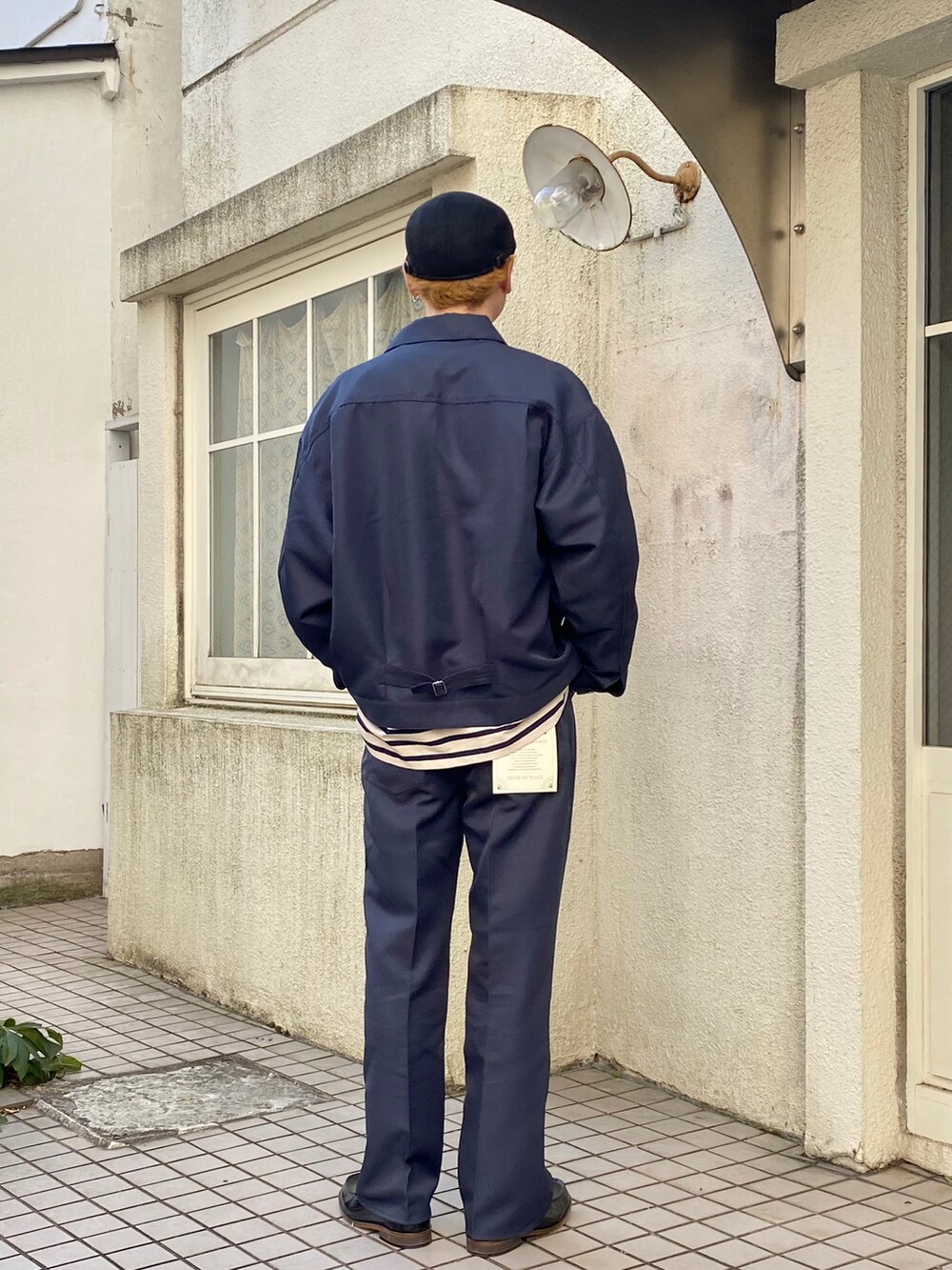 ブルー系のブルゾン、ブルー系のTシャツ/カットソー、ブルー系のスラックスを着用したメンズの冬コーディネートの3枚目の写真