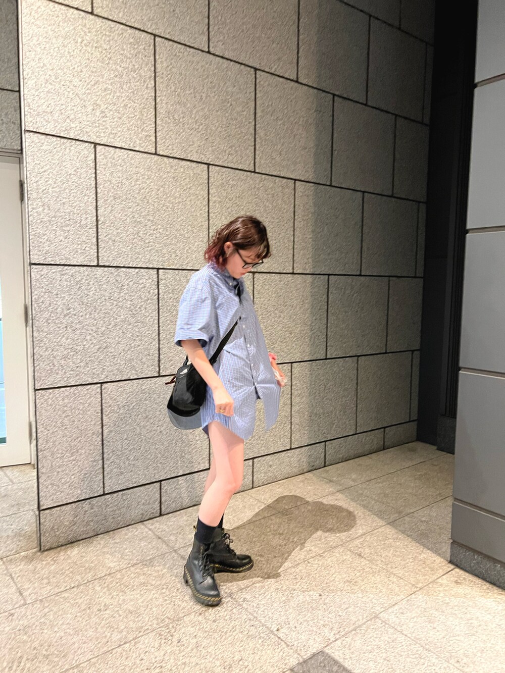 ブラック系のショルダーバッグ、ブルー系のシャツ/ブラウス、ブラック系のシューズを着用したレディースの夏コーディネートの2枚目の写真