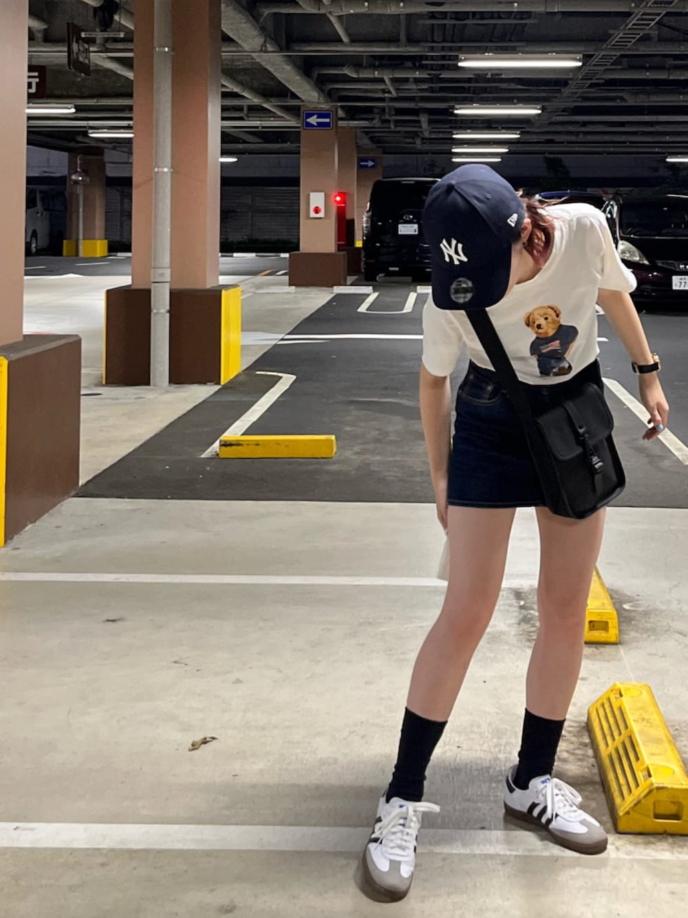 ホワイト系のTシャツ/カットソー、ブルー系のデニムスカート、ホワイト系のスニーカーを着用したレディースの夏コーディネートの2枚目の写真