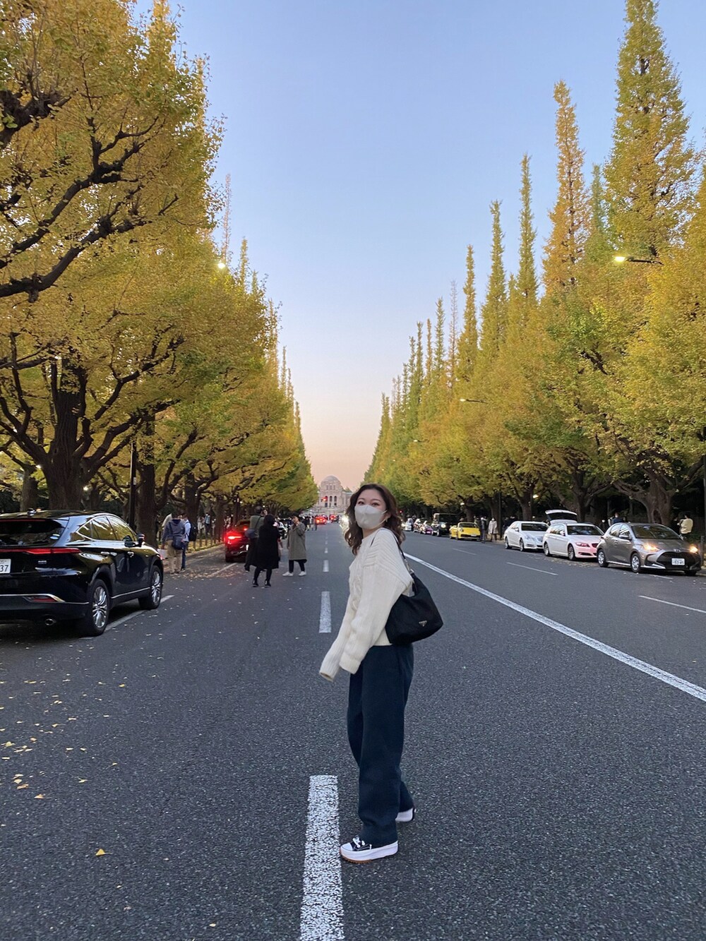 ブルー系のパンツ、ブラック系のスニーカー、ホワイト系のニット/セーターを着用したレディースの秋コーディネートの2枚目の写真