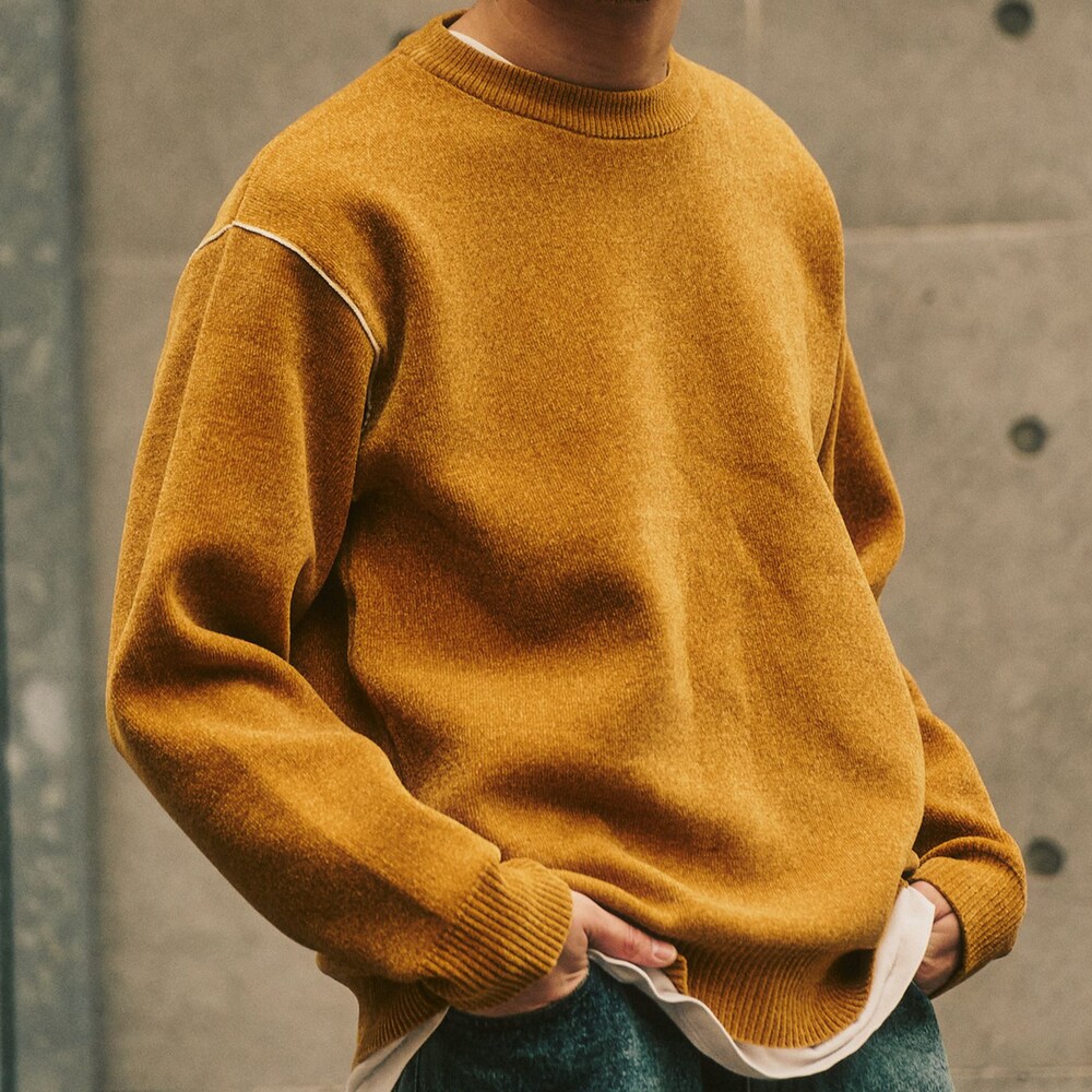 ブルー系のデニムパンツ、イエロー系のニット/セーターを着用したメンズの冬コーディネートの2枚目の写真