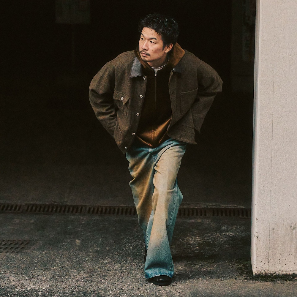 グリーン系のカバーオール、ブルー系のデニムパンツ、ブラウン系のパーカーを着用したメンズの冬コーディネートの5枚目の写真