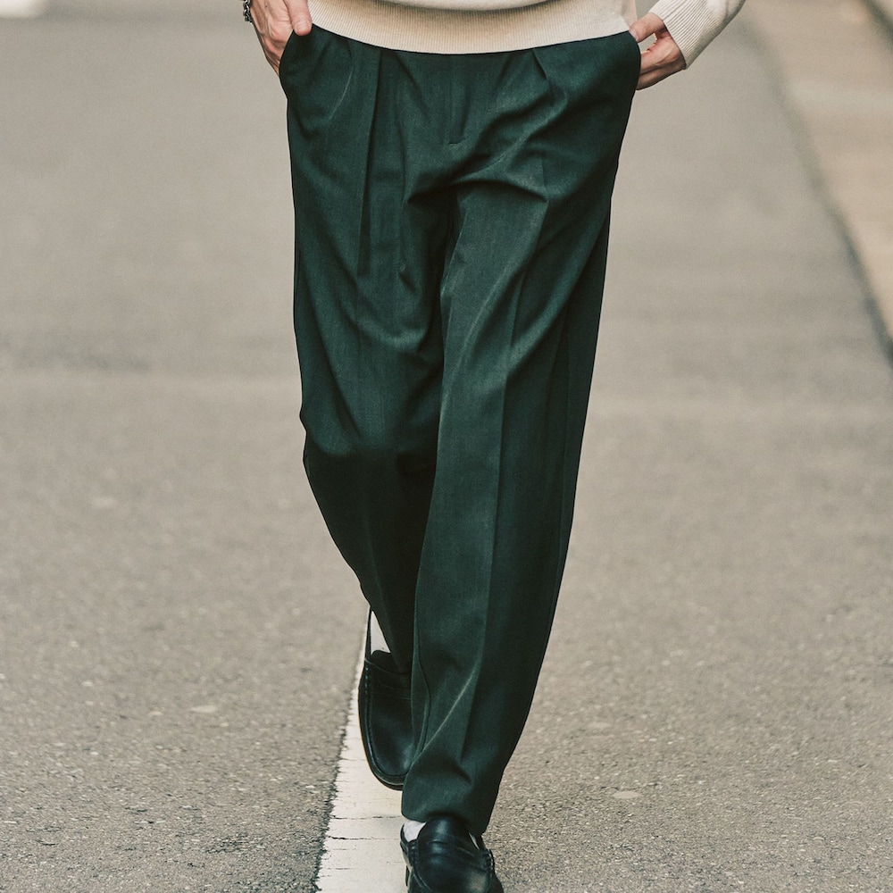 グリーン系のスラックス、ホワイト系のニット/セーターを着用したメンズの冬コーディネートの2枚目の写真