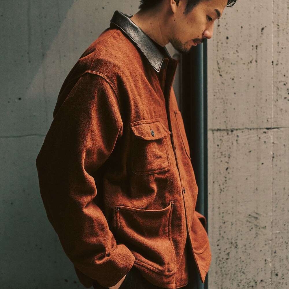 レッド系のカバーオール、ブラック系のスラックスを着用したメンズの冬コーディネートの2枚目の写真