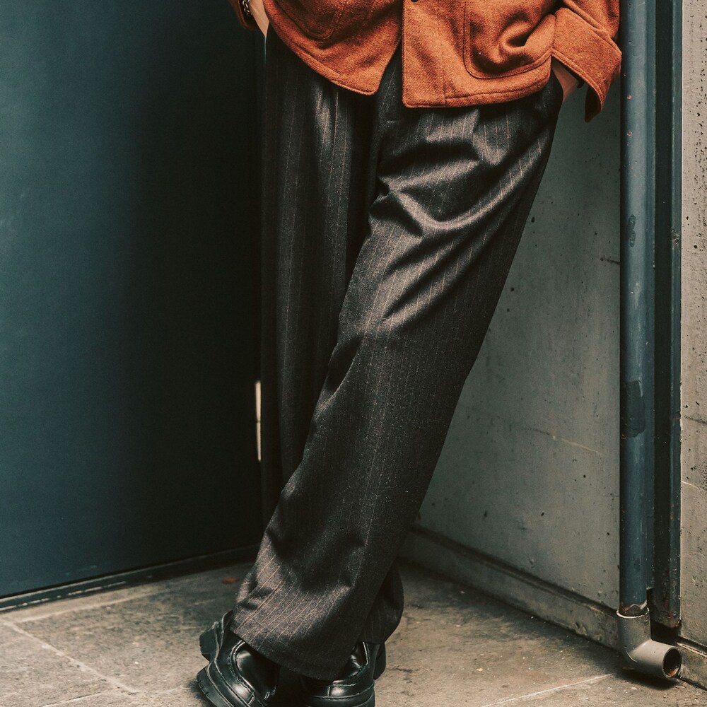 レッド系のカバーオール、ブラック系のスラックスを着用したメンズの冬コーディネートの4枚目の写真