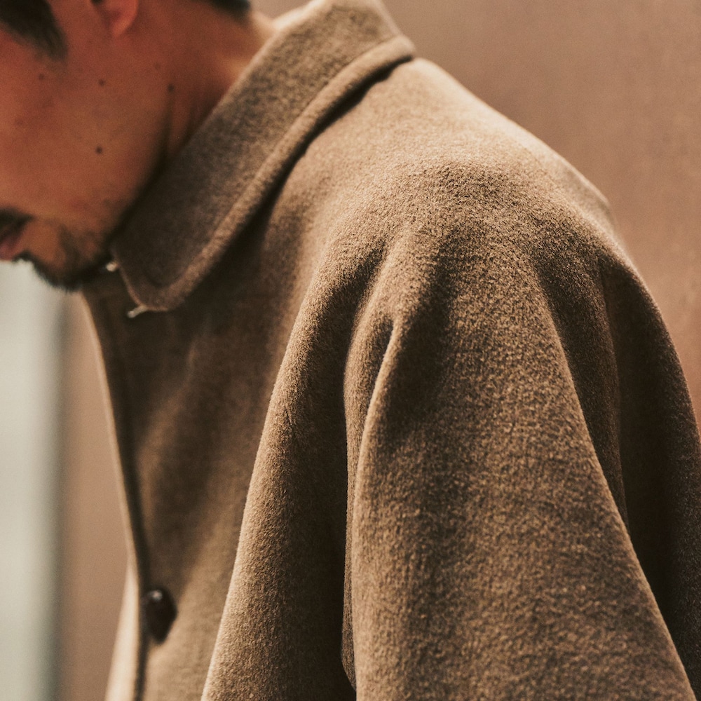 イエロー系のその他アウター、ブラウン系のスラックスを着用したメンズの冬コーディネートの3枚目の写真