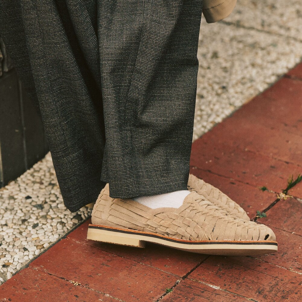 ブラウン系のテーラードジャケット、ベージュ系のステンカラーコート、ブラウン系のスラックスを着用したメンズの冬コーディネートの6枚目の写真