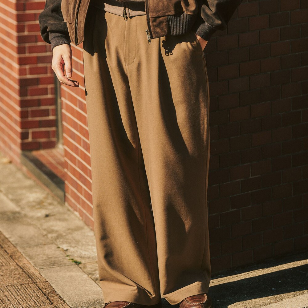 ブラウン系のライダースジャケット、ベージュ系のスラックス、ベージュ系のパーカーを着用したメンズの冬コーディネートの5枚目の写真