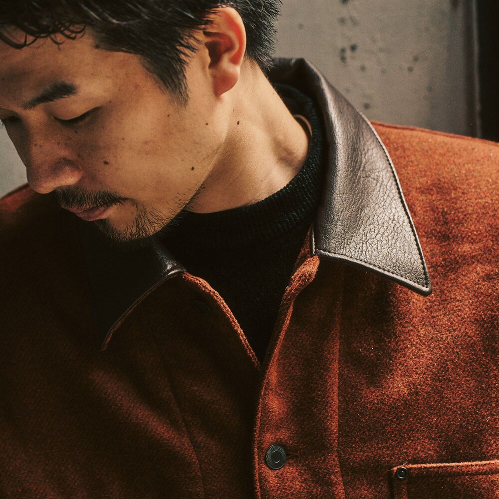 レッド系のカバーオール、ブラック系のスラックスを着用したメンズの冬コーディネートの3枚目の写真