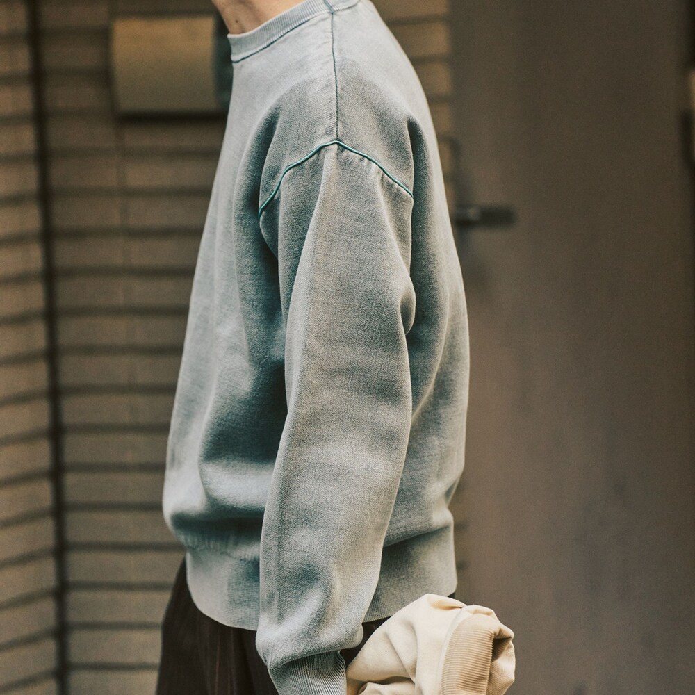 グレー系のニット/セーター、ベージュ系のその他アウター、ブラウン系のスラックスを着用したメンズの冬コーディネートの7枚目の写真