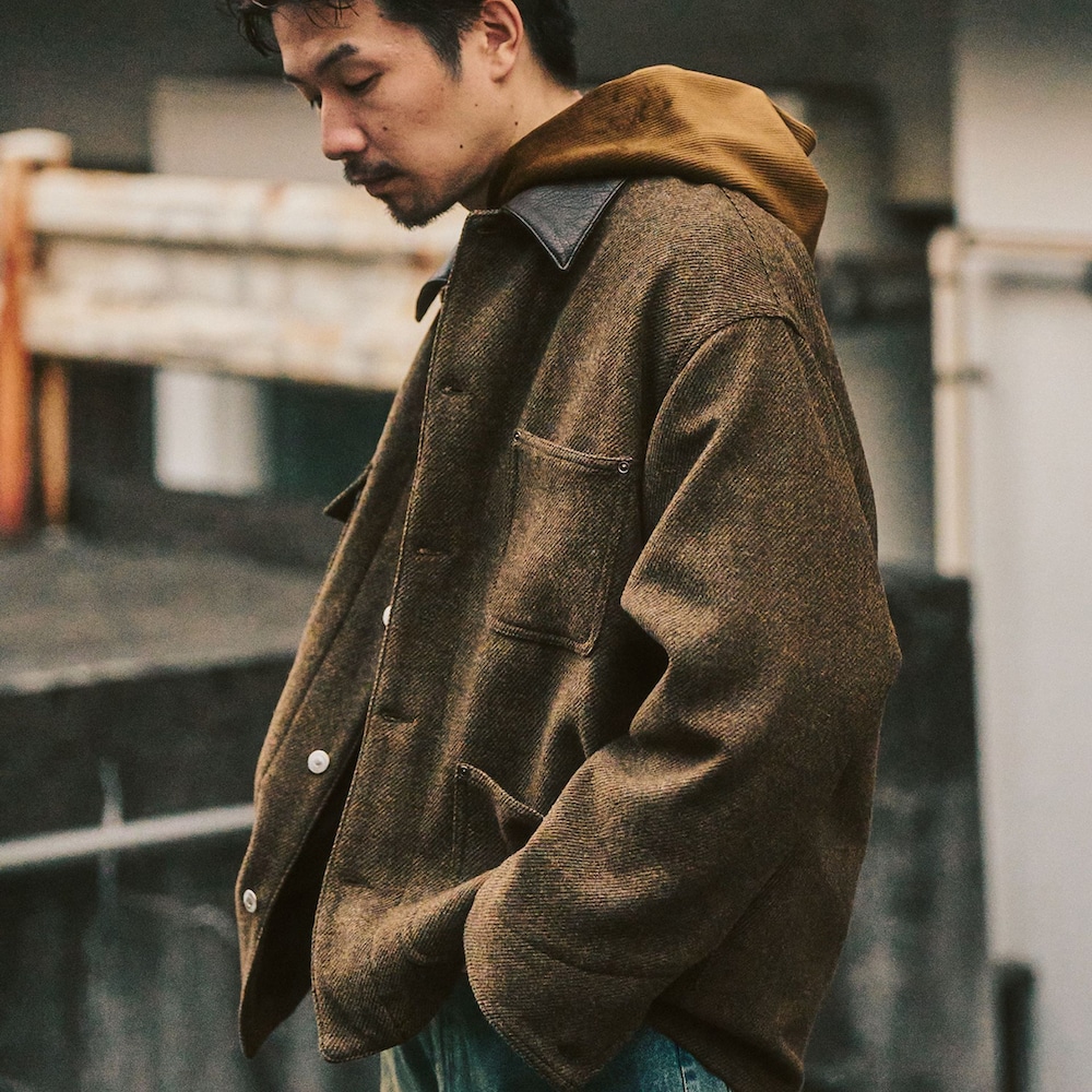 グリーン系のカバーオール、ブルー系のデニムパンツ、ブラウン系のパーカーを着用したメンズの冬コーディネートの2枚目の写真