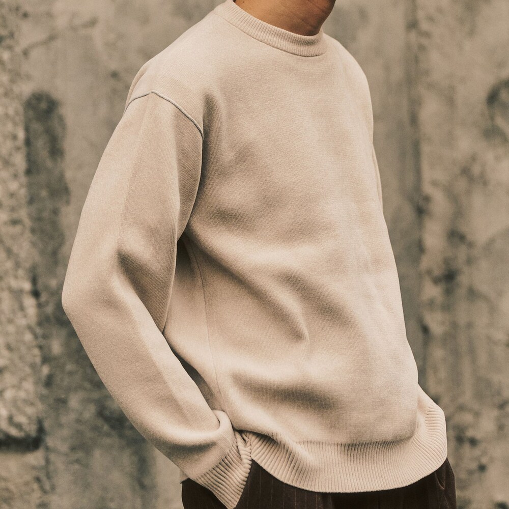 ブラウン系のステンカラーコート、ホワイト系のニット/セーターを着用したメンズの冬コーディネートの2枚目の写真