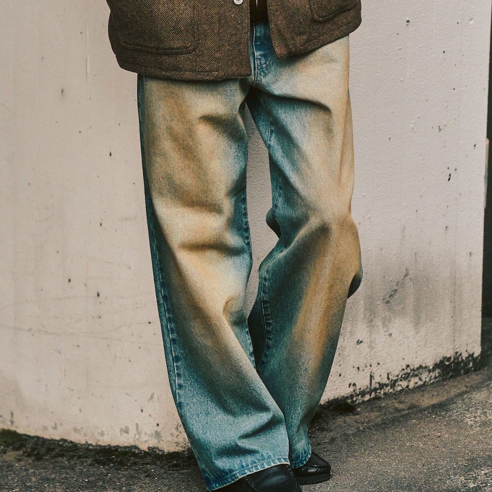 グリーン系のカバーオール、ブルー系のデニムパンツ、ブラウン系のパーカーを着用したメンズの冬コーディネートの3枚目の写真