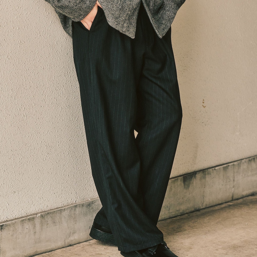 グレー系のカバーオール、ブラック系のスラックスを着用したメンズの冬コーディネートの3枚目の写真