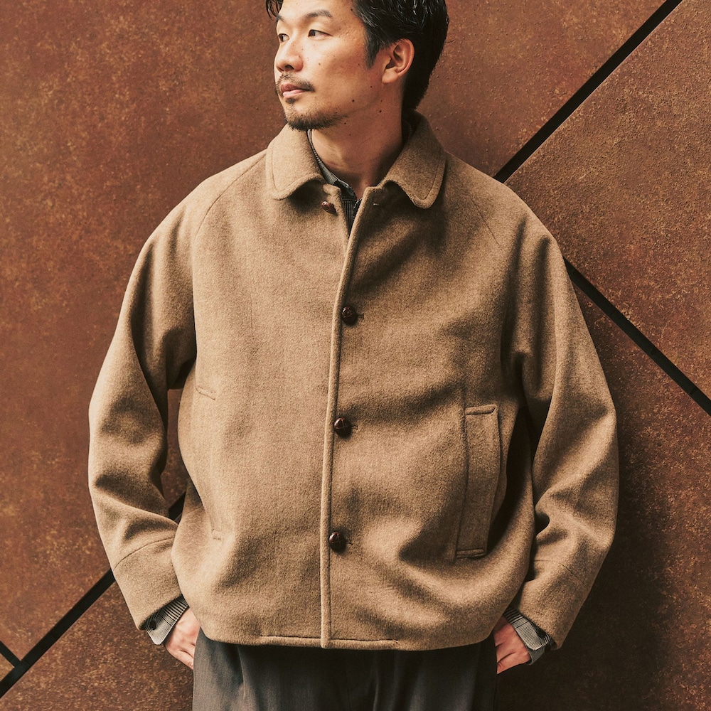 イエロー系のその他アウター、ブラウン系のスラックスを着用したメンズの冬コーディネートの2枚目の写真