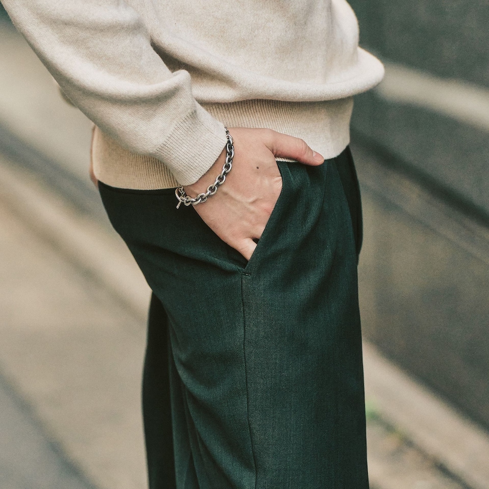 グリーン系のスラックス、ホワイト系のニット/セーターを着用したメンズの冬コーディネートの3枚目の写真